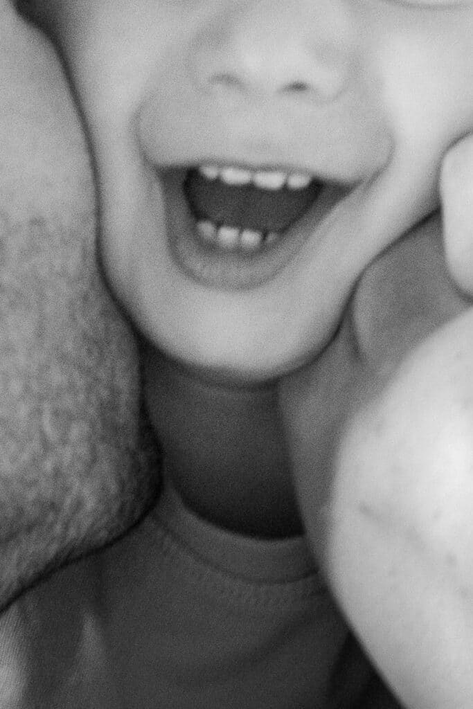 photo de famille les deux parents font un bisou sur la joue de leur enfant