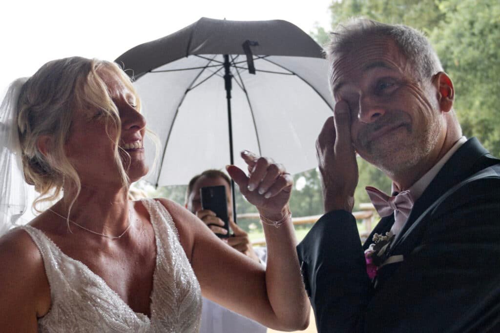 Marié ému avec son témoin sous un parapluie