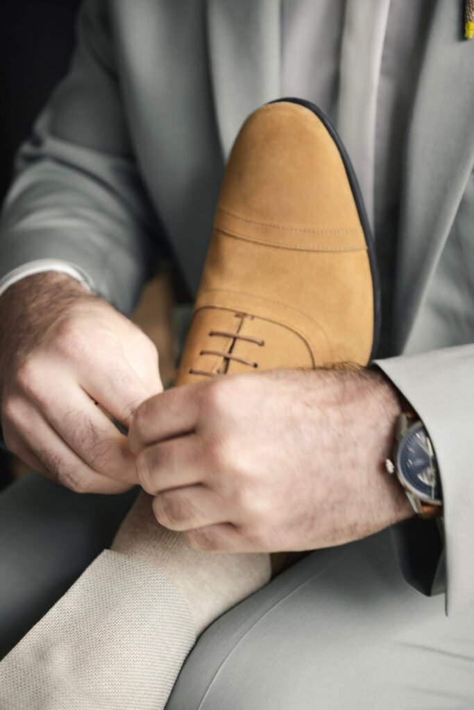 Un ami qui aide le marié à lacer ses chaussures